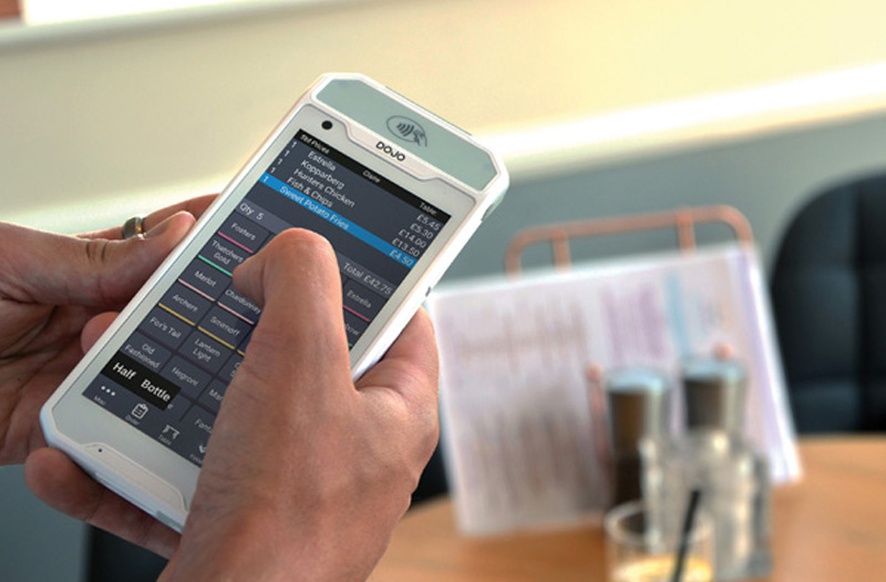 Waiter taking an order at the table using tablet with software