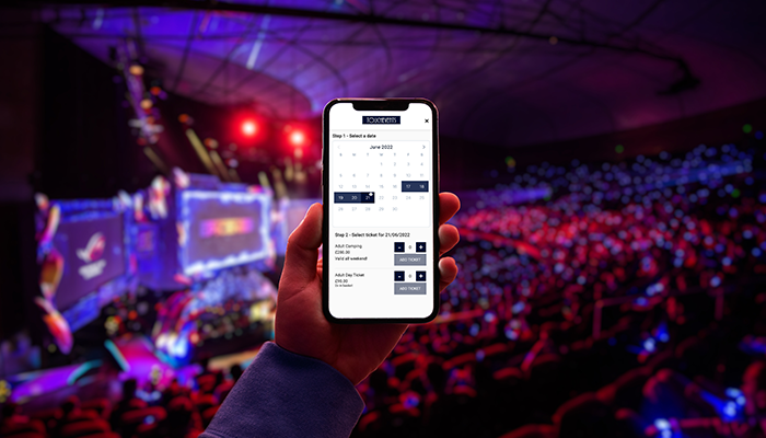 Person holding phone at concert showing ticket options